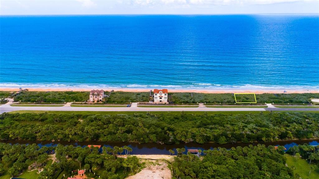 An aerial view shows a vacant oceanfront lot highlighted in yellow between two existing houses — 3721 N OCEAN SHORE BOULEVARD, PALM COAST, FL
