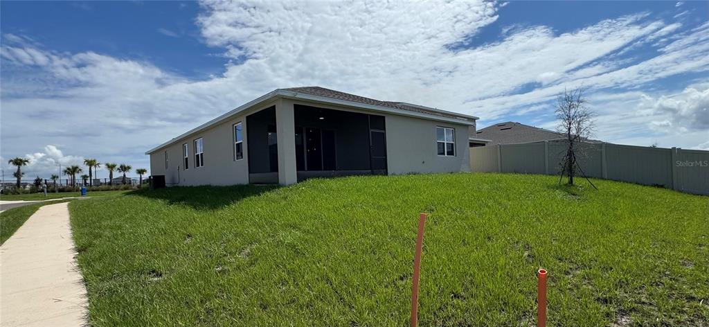 A tan, single-story suburban house with a two-car garage and dark blue shutters — 5442 CATMINT DRIVE, HAINES CITY, FL