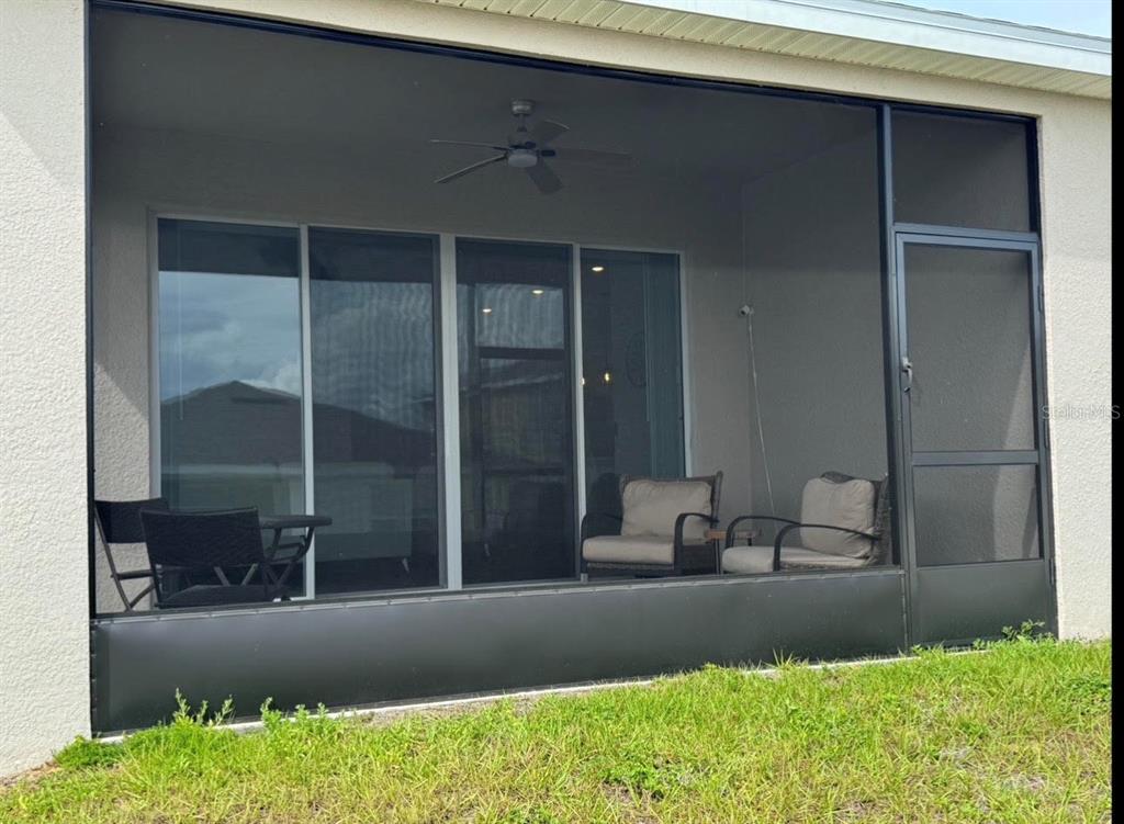 The exterior view shows the back of a house with a screened-in patio — 5442 CATMINT DRIVE, HAINES CITY, FL