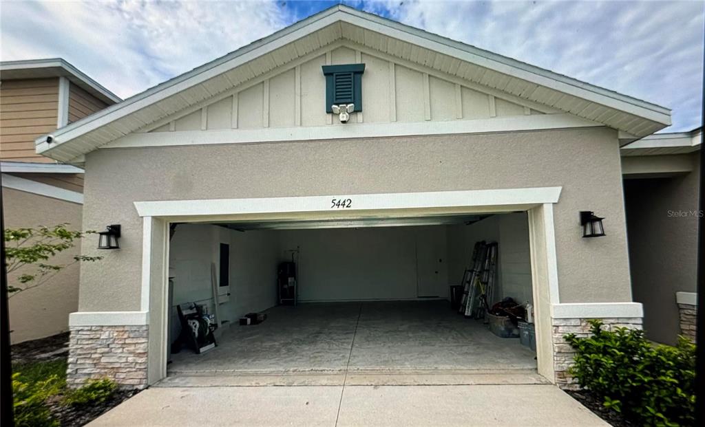 A screened-in patio features a ceiling fan, sliding glass doors, and outdoor furniture — 5442 CATMINT DRIVE, HAINES CITY, FL