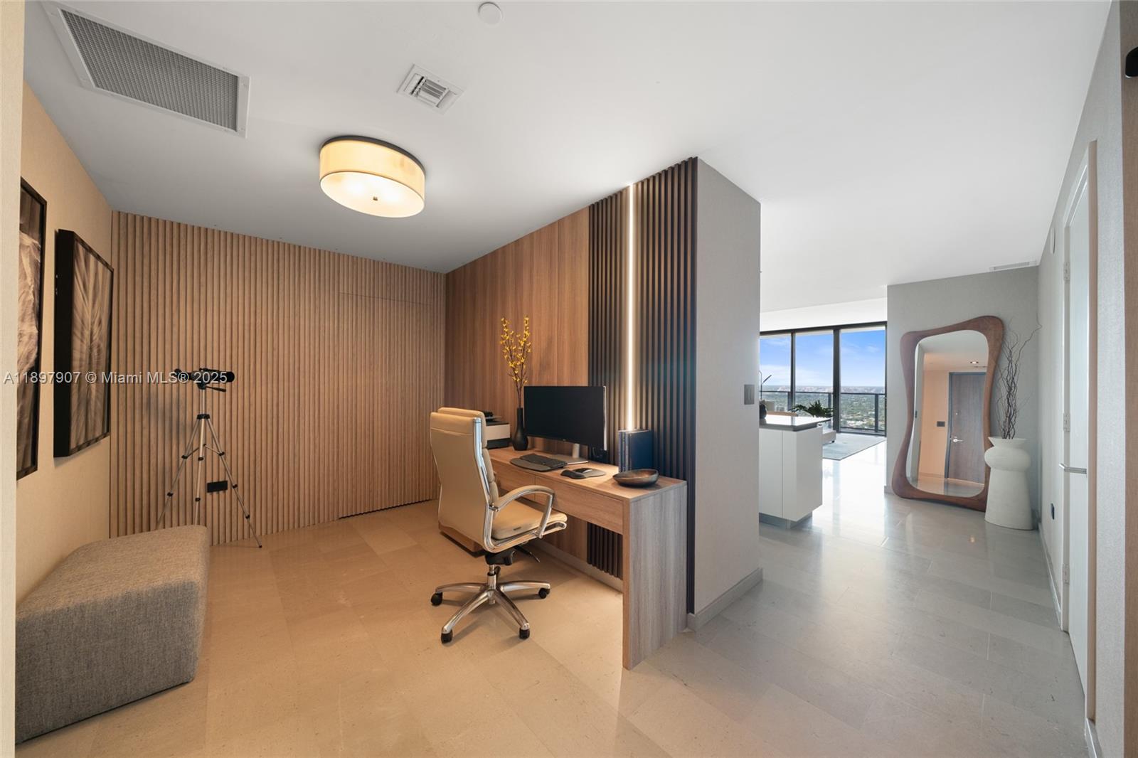 A modern home office features wood-slat wall paneling, a built-in desk, and a tall floor mirror — 88 SW 7th St # 3910, Miami FL 33130, MIAMI, FL