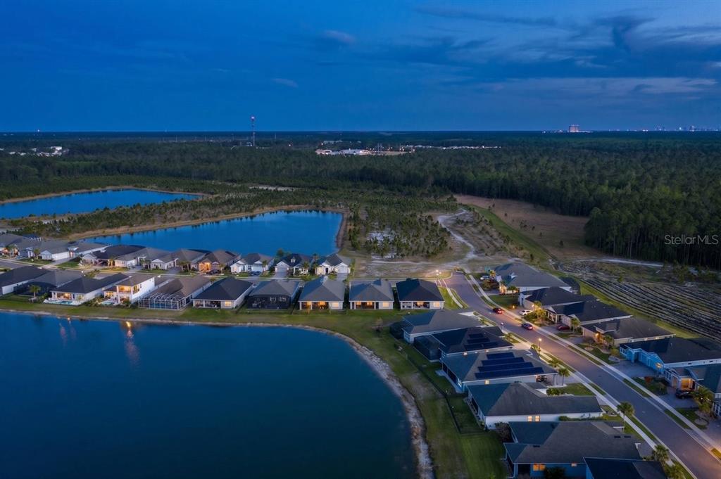 An aerial view of a suburban neighborhood with houses situated along a large lake — 260 FUCHSIA STREET, DAYTONA BEACH, FL