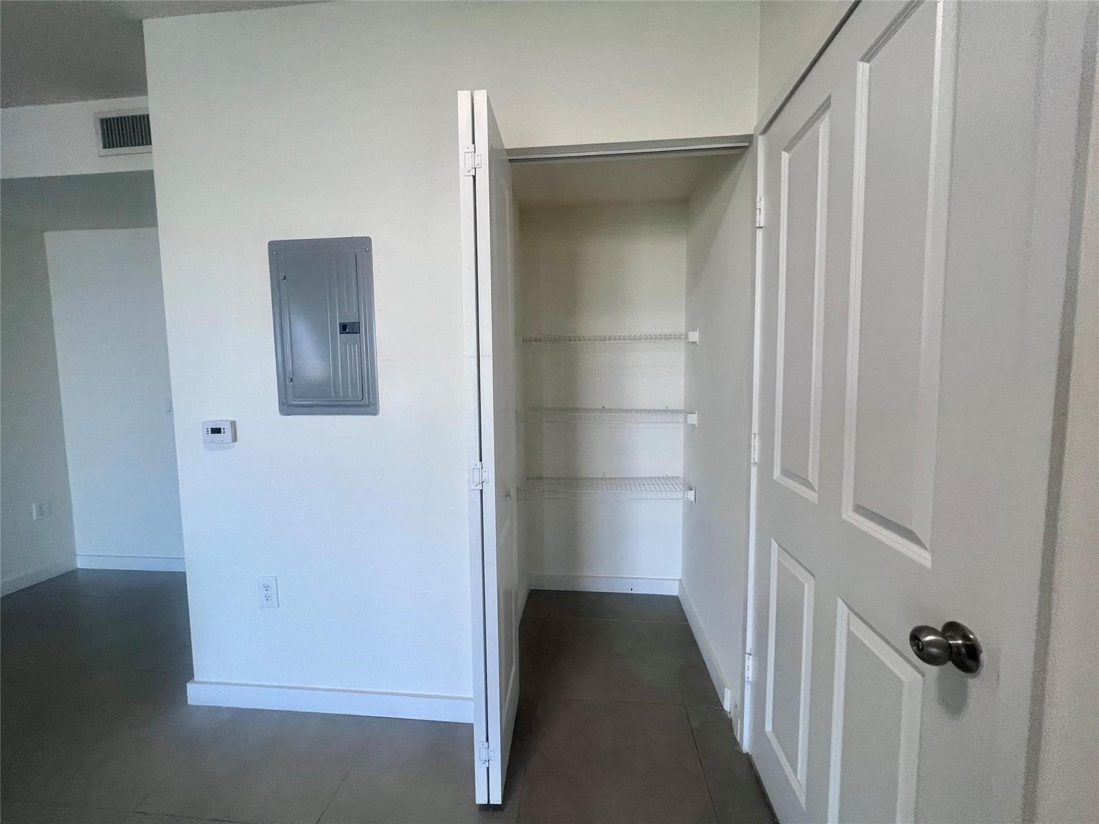 A room features a closet with wire shelving, a breaker panel, and tile flooring — 729 NW 2 Street # 501, Miami FL 33128, MIAMI, FL