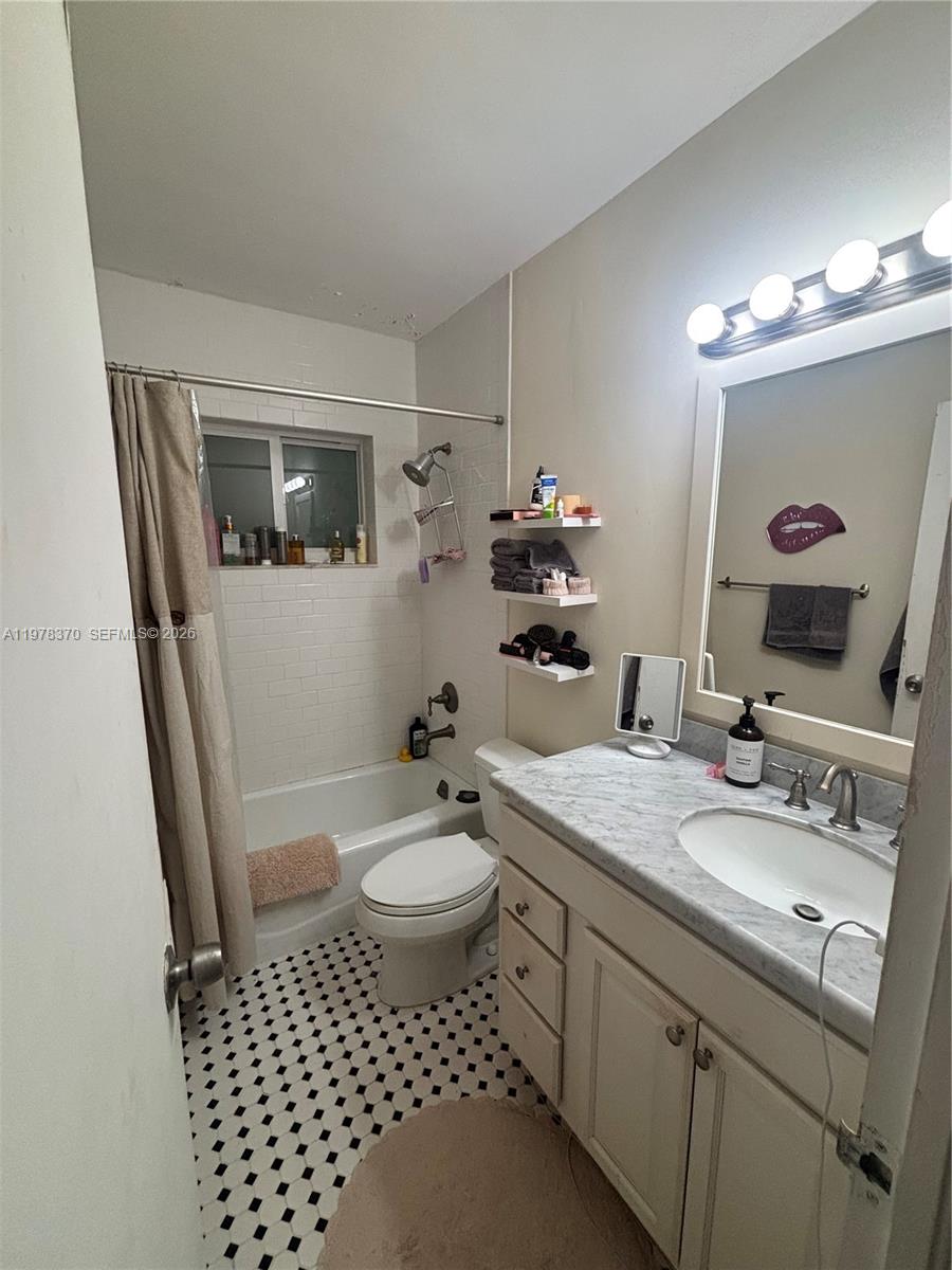 A bathroom features a white vanity, a shower-tub combination, and black-and-white tiled flooring — 75 Washington Ave # 12A, Miami Beach FL 33139, MIAMI BEACH, FL