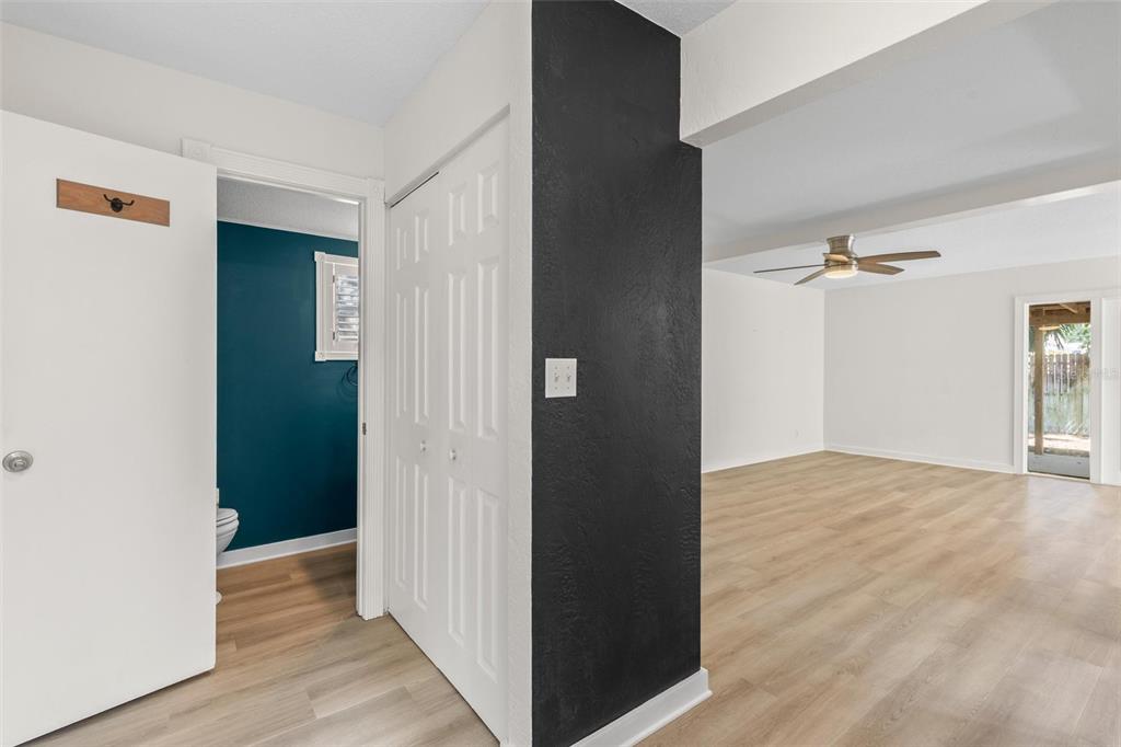 A view of a hallway with a black accent wall, closet, and adjacent living area — 108 NORTHBROOK LANE, ORMOND BEACH, FL