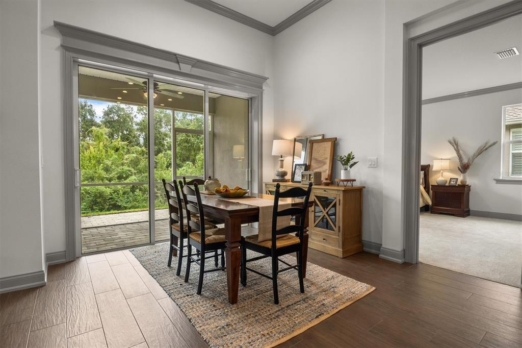 A dining area with a wooden table, chairs, and sliding glass doors leading to a patio — 7911 LAKE JAMES BOULEVARD, LAKELAND, FL