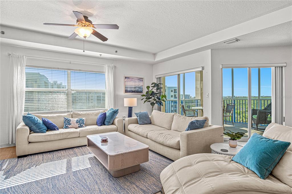 A living room features two beige sofas, a coffee table, and a balcony with seating — 5300 S ATLANTIC AVENUE UNIT 10501, NEW SMYRNA BEACH, FL