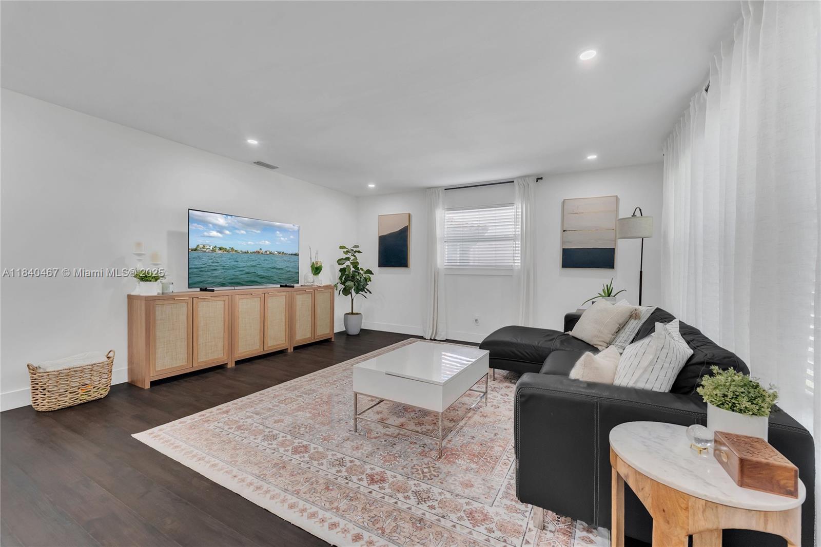 A living room features a black sectional sofa, a white coffee table, and a wooden console — 2851 Washington St, Hollywood FL 33020, HOLLYWOOD, FL