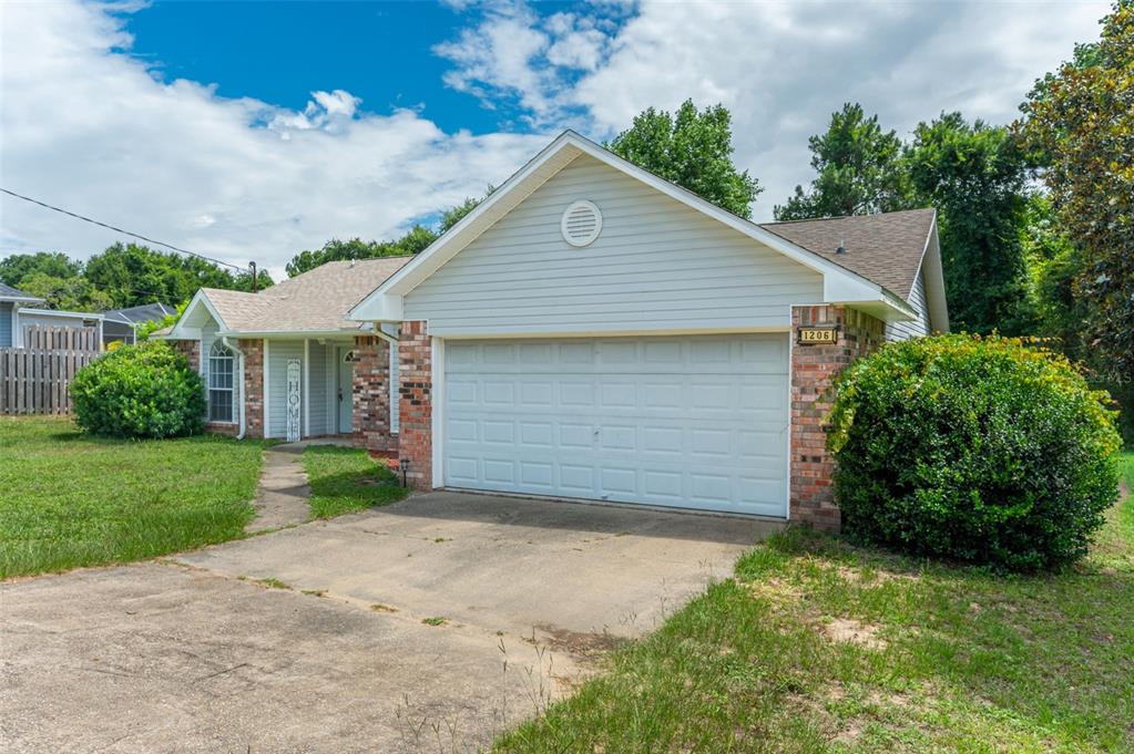 A single-story house with a brick and light-colored siding exterior, a garage, and a driveway — 1206 EGO DRIVE, CRESTVIEW, FL