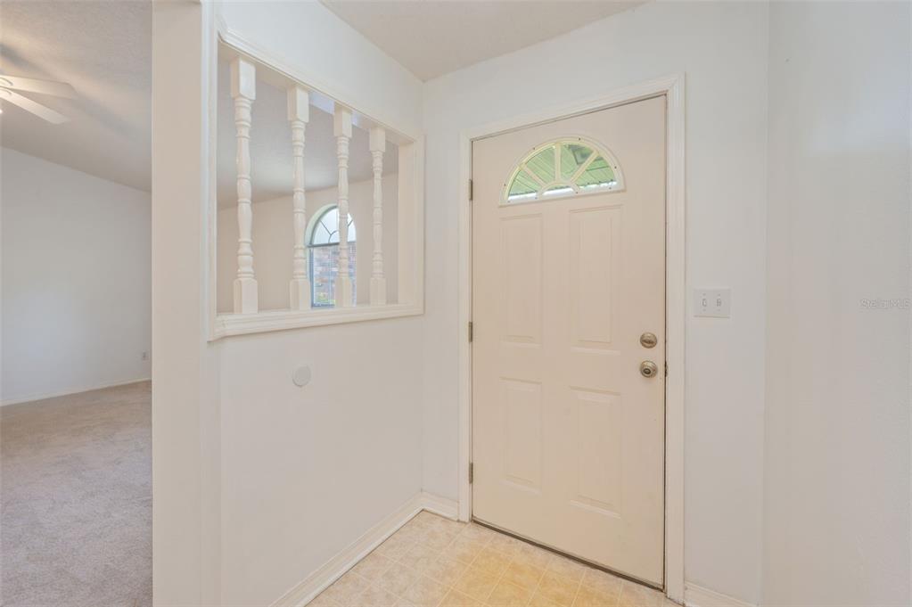An entryway features a white door with a semi-circular window and a decorative spindle partition — 1206 EGO DRIVE, CRESTVIEW, FL