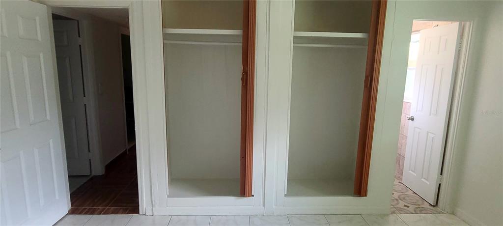 A room features two open closets between two white doors leading to other spaces — 301 HOPE CIRCLE, ORLANDO, FL