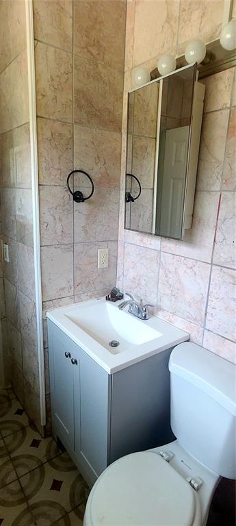 A bathroom features a gray vanity, a medicine cabinet, and light-colored marble-style wall tiles — 301 HOPE CIRCLE, ORLANDO, FL