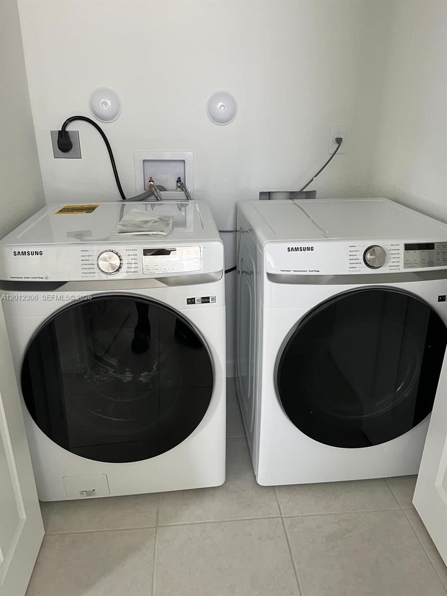 A laundry closet contains a white Samsung front-load washer and dryer set — 12912 SW 233rd Ter, Homestead FL 33032, HOMESTEAD, FL
