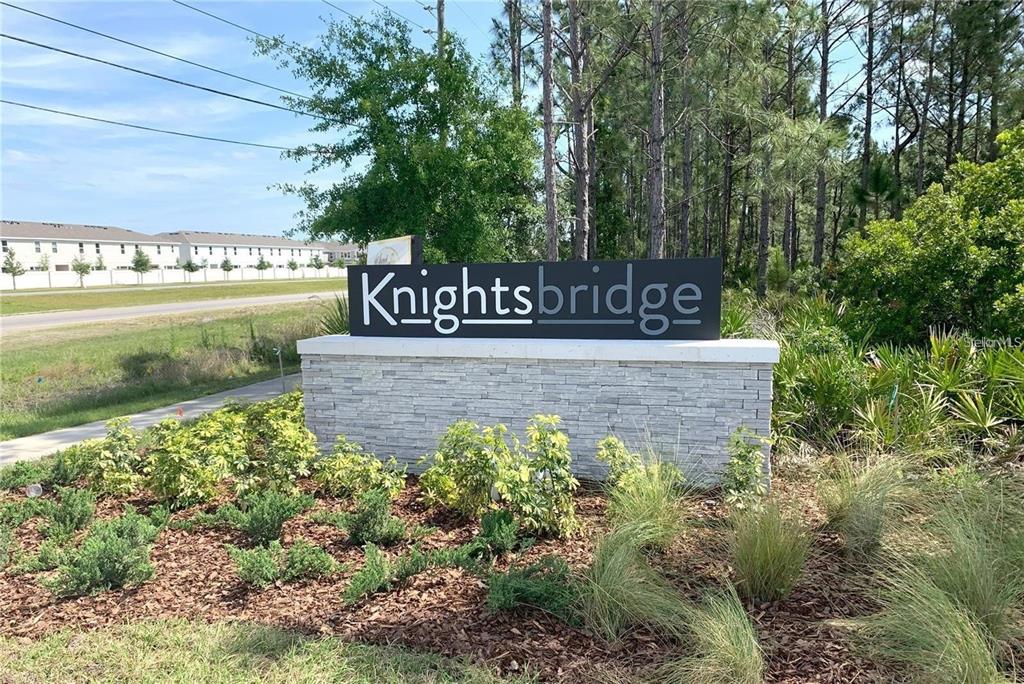 A stone monument sign for the Knightsbridge community stands in a landscaped area near trees — 1373 BRENTWOOD DR, KISSIMMEE, FL