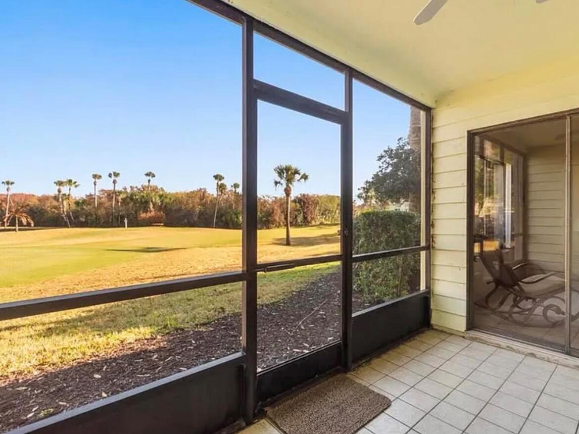 A screened-in porch with tiled flooring overlooks a grassy golf course — 5790 Marina Drive # 2, Sebastian FL 32958, SEBASTIAN, FL