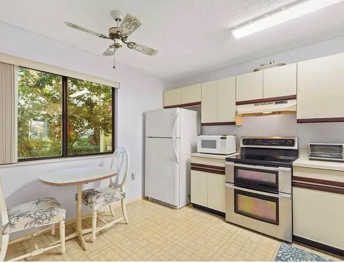 A kitchen features light-colored cabinets, a stainless steel double oven, and a small dining area — 5790 Marina Drive # 2, Sebastian FL 32958, SEBASTIAN, FL