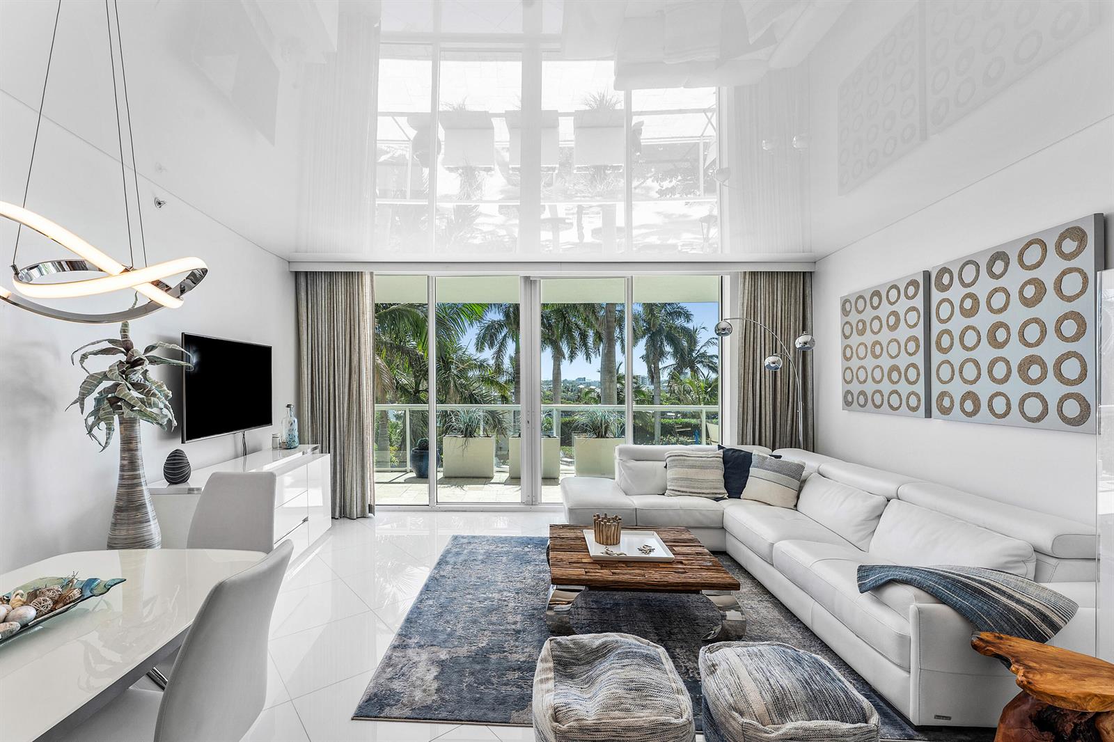 A modern living room features white tile floors, a white sectional sofa, and floor-to-ceiling windows — 1 N Ocean Boulevard # 513, Pompano Beach FL 33062, POMPANO BEACH, FL