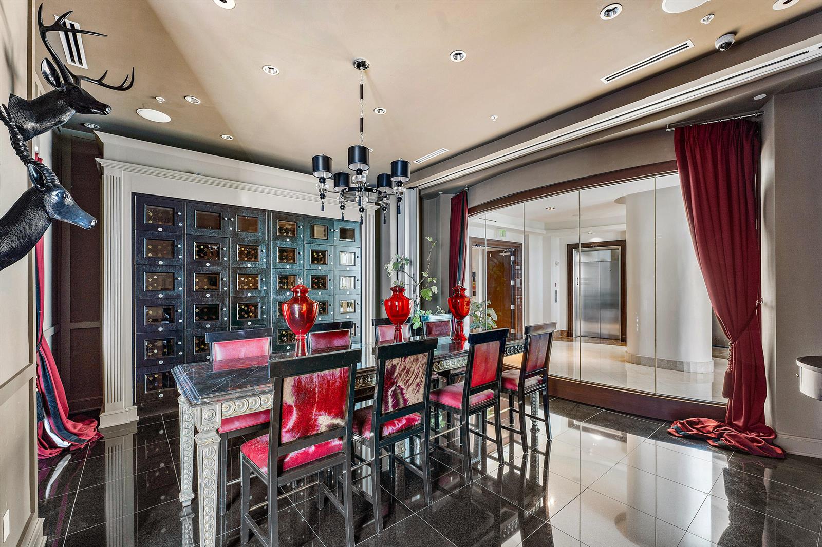 A formal dining room features a dark table, red-upholstered chairs, a wine storage wall, and mirrors — 1 N Ocean Boulevard # 513, Pompano Beach FL 33062, POMPANO BEACH, FL