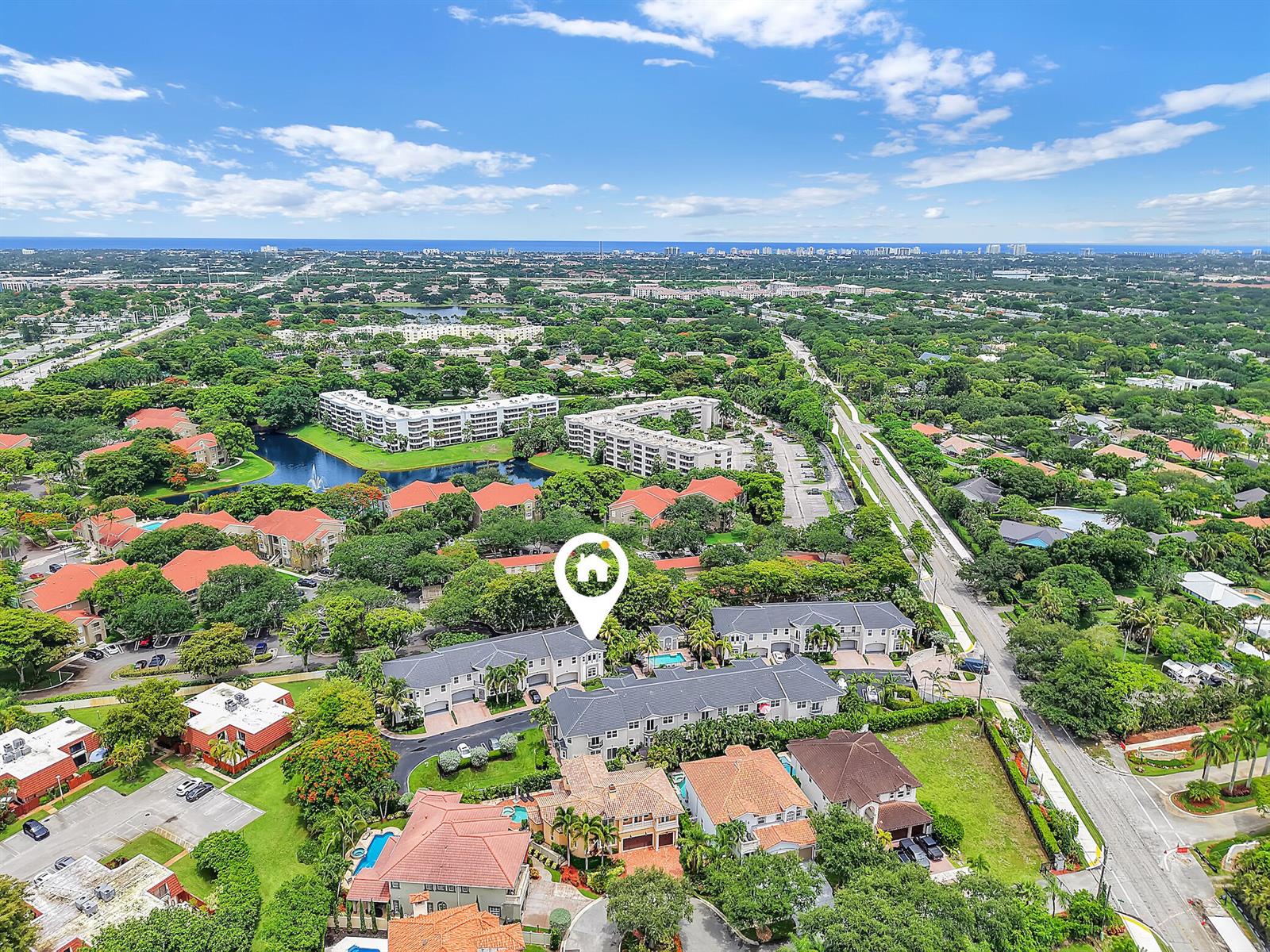 An aerial view shows a residential neighborhood with townhomes, houses, and a nearby lake — 1835 Highland Grove Drive, Delray Beach FL 33445, DELRAY BEACH, FL