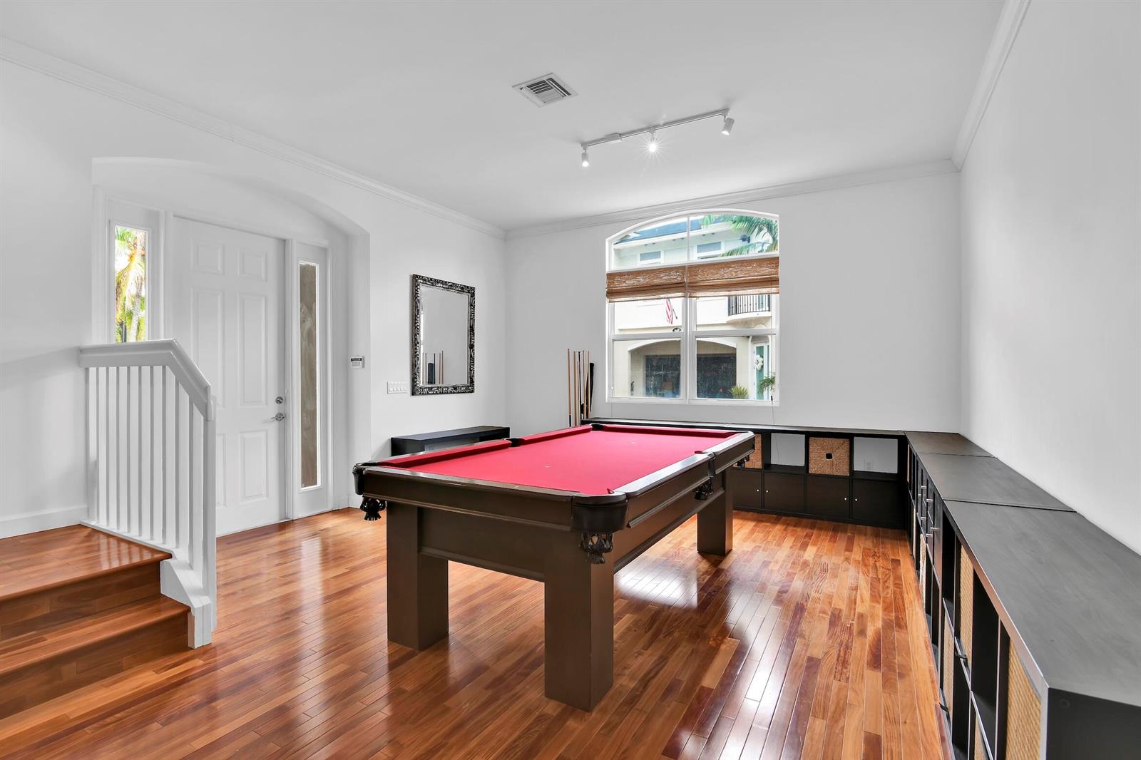 A game room features a red pool table, hardwood floors, and built-in storage cabinets — 1835 Highland Grove Drive, Delray Beach FL 33445, DELRAY BEACH, FL