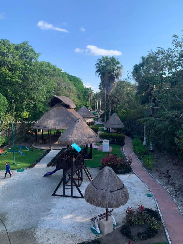 An outdoor park area features thatched-roof gazebos, a wooden playground, and a paved walking path — MZ10 L25 Calle Isla, TX 77586, TX