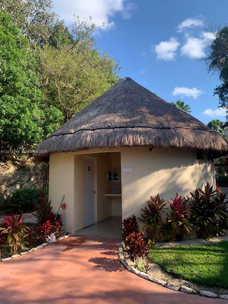 A small, round building with a thatched roof sits along a paved walkway — MZ10 L25 Calle Isla, TX 77586, TX