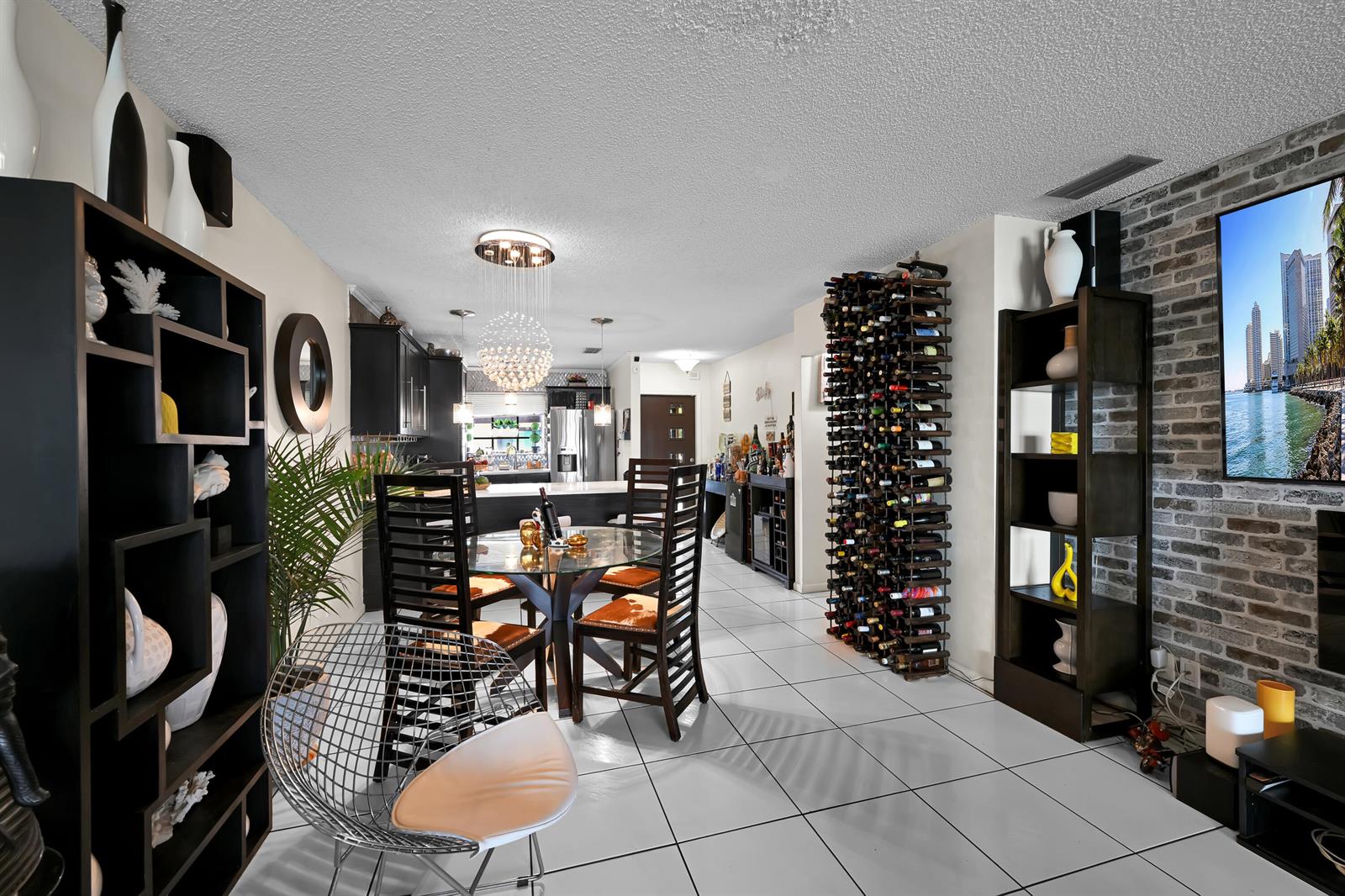 A dining area and living space feature a wine rack, tiled floors, and brick wall — 627 Banks Road # 48, Margate FL 33063, MARGATE, FL