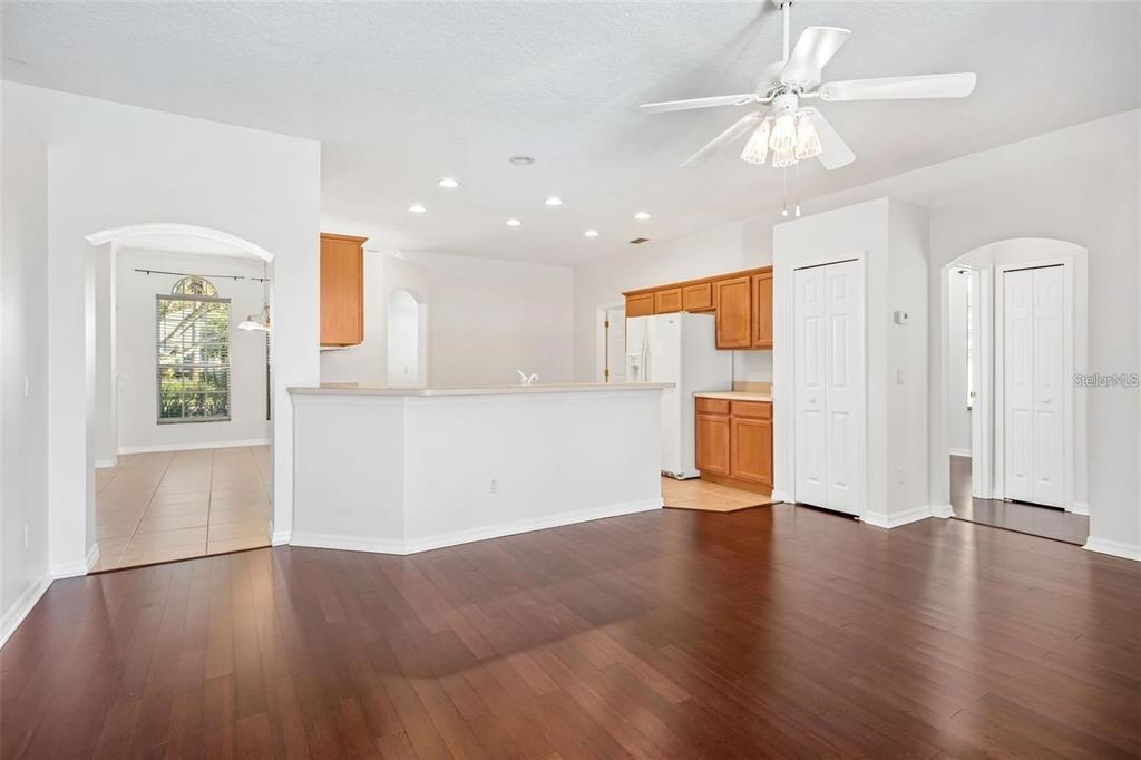 A kitchen with wood cabinets and a breakfast bar overlooks a hardwood-floored living area — 9651 OLD MARSH COURT, ORLANDO, FL