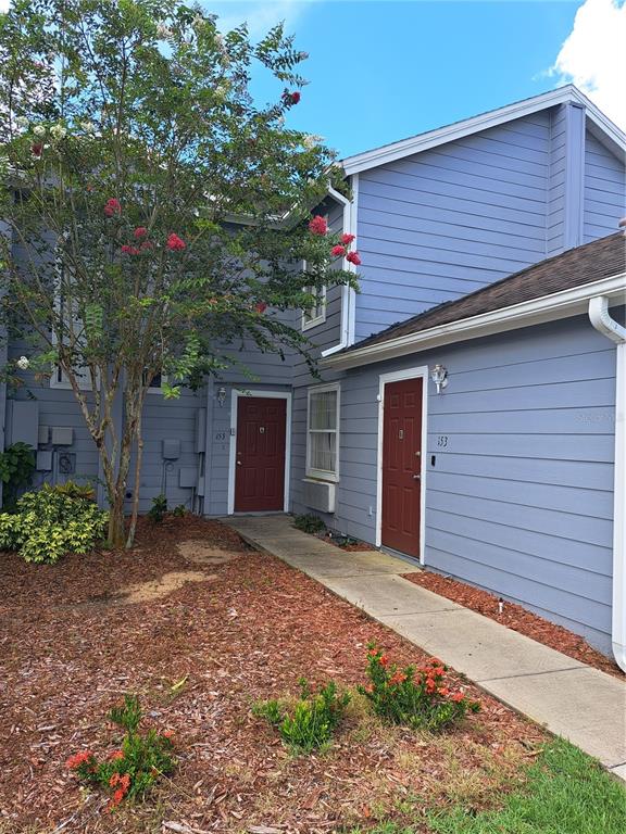 A two-story blue building with two red doors and a concrete walkway — 153 MANGO DRIVE, DAVENPORT, FL