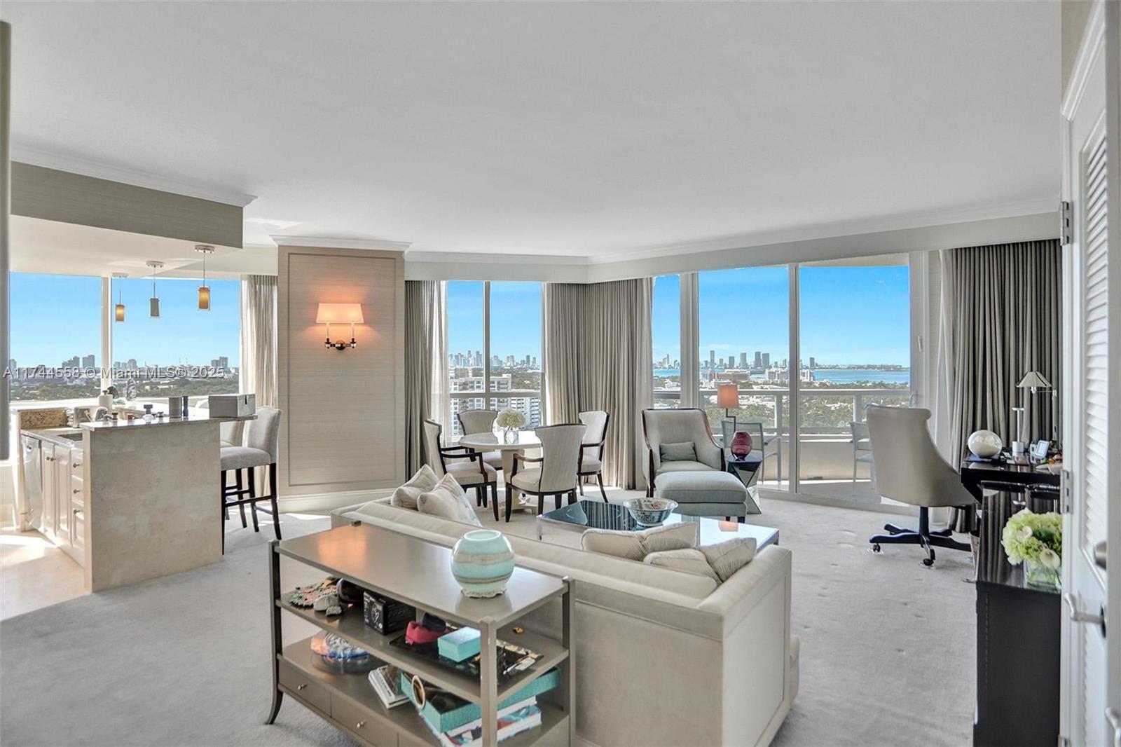 A bright living room features a kitchen island, dining area, and floor-to-ceiling windows with views — 4401 Collins Ave, Miami Beach FL 33140, MIAMI BEACH, FL