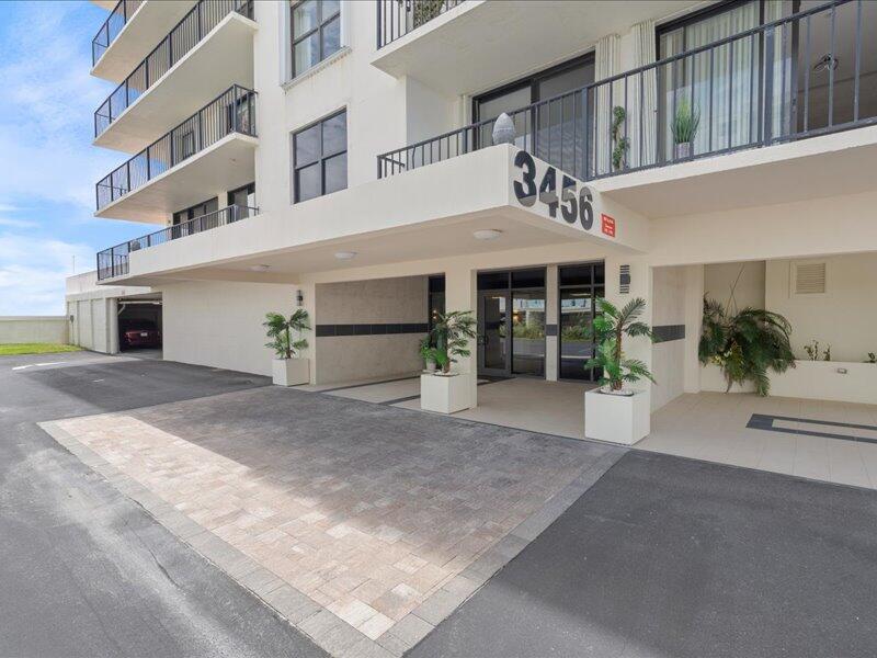 The exterior of a multi-story apartment building features a covered entrance with paved driveway — 3456 S Ocean Boulevard # 505, Palm Beach FL 33480, PALM BEACH, FL