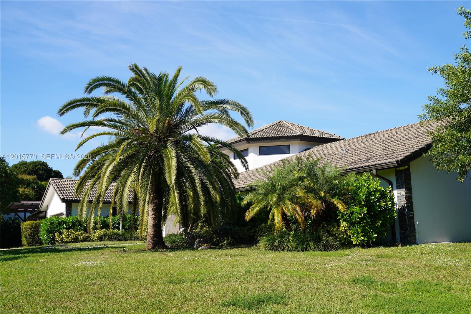 A large palm tree stands in front of a house with a tiled roof — 18901 SW 50th ST, Southwest Ranches FL 33332, SOUTHWEST RANCHES, FL