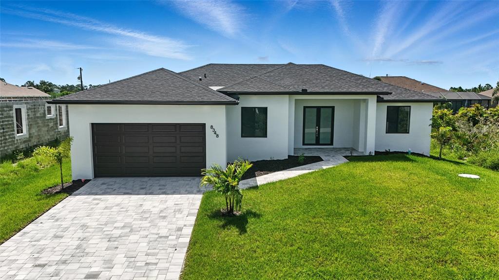 A single-story house with a white exterior, dark roof, and a paved driveway — 8348 WALDEN STREET, PORT CHARLOTTE, FL