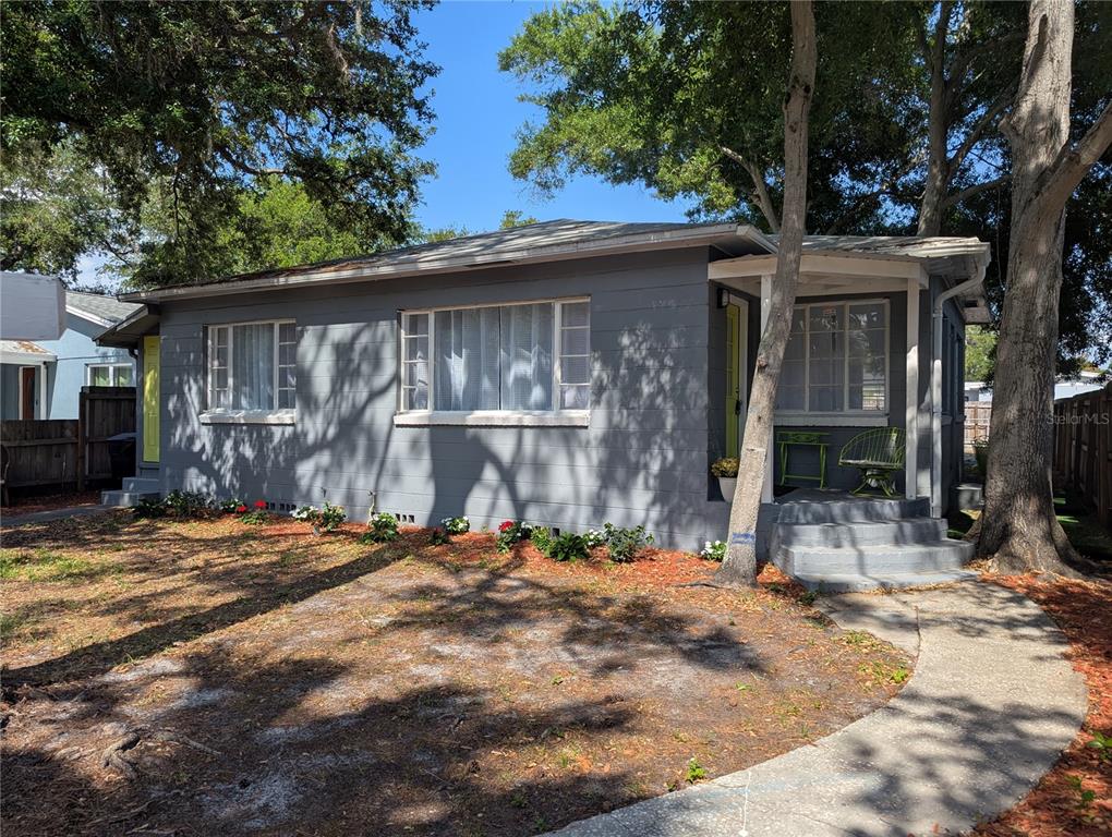 A gray, single-story house with a concrete walkway and mature trees in the front yard — 3834 DR MARTIN LUTHER KING JR STREET S, ST PETERSBURG, FL