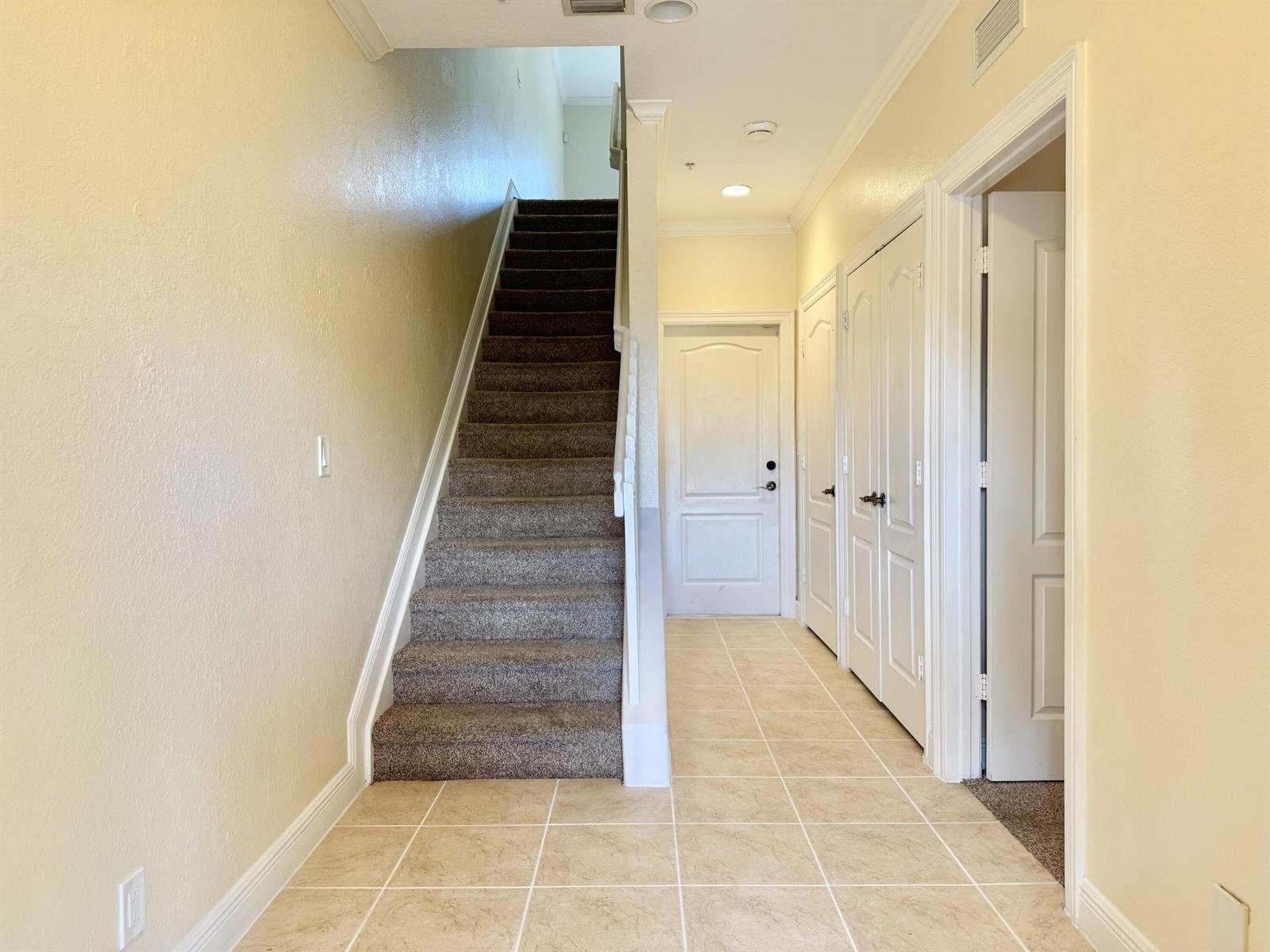 A carpeted staircase leads upward next to a tiled hallway with several white doors — 531 S Federal Highway # 15, FL 33460, FL