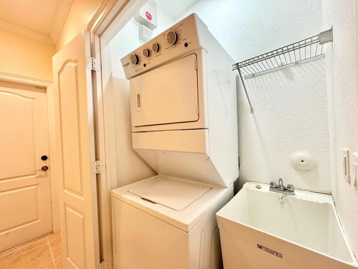 A laundry room features a stacked washer and dryer unit next to a utility sink — 531 S Federal Highway # 15, FL 33460, FL