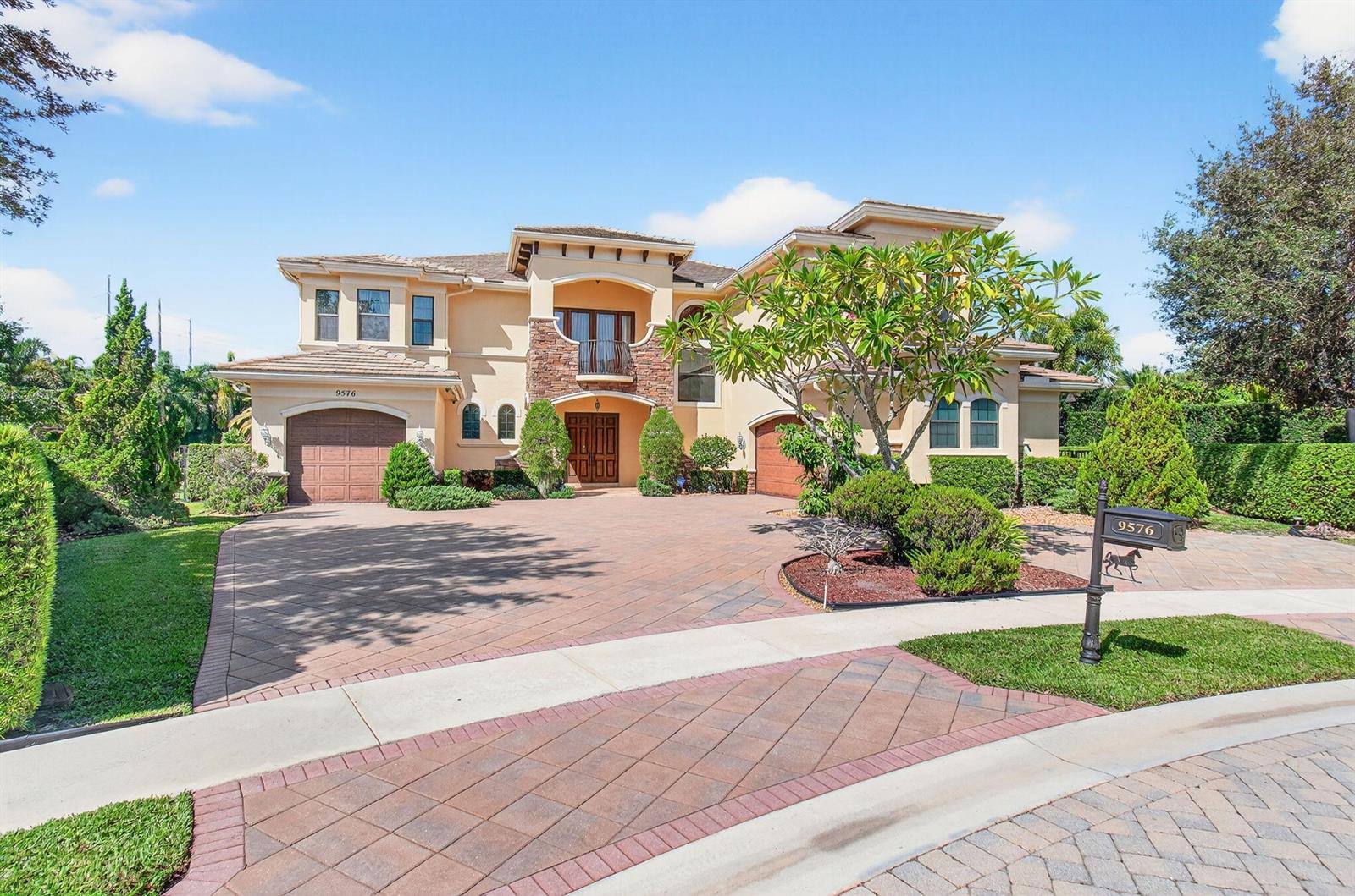 A two-story stucco house with a stone facade, arched entryway, and a paved driveway — 9576 Equus Circle, Boynton Beach FL 33472, BOYNTON BEACH, FL