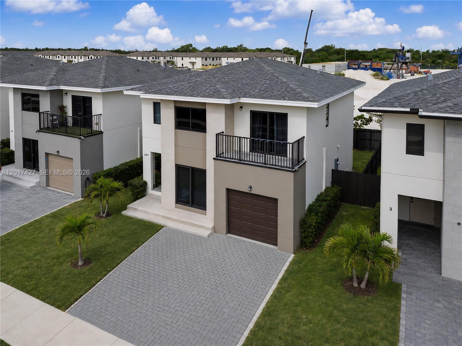 An aerial view shows a modern two-story house with a paved driveway and balcony — 227 NW 13th Pl, Florida City FL 33034, FLORIDA CITY, FL