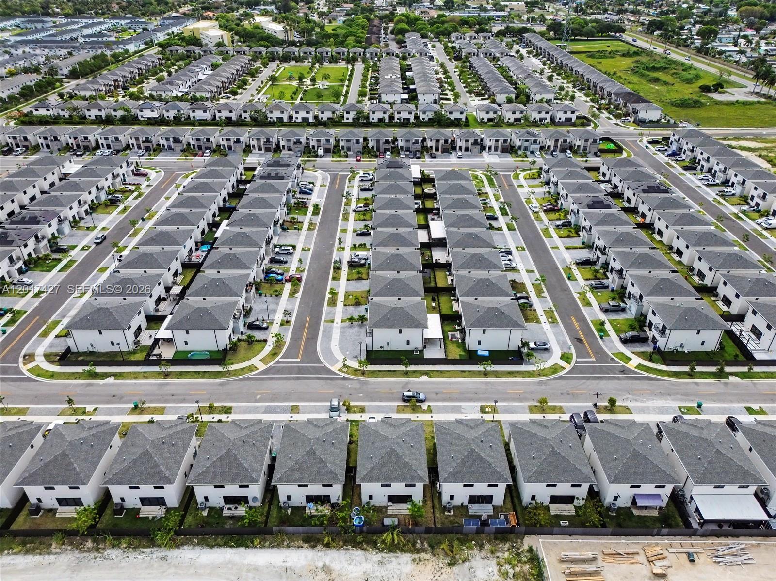 An aerial view shows a dense residential neighborhood of modern townhouses with gray roofs — 227 NW 13th Pl, Florida City FL 33034, FLORIDA CITY, FL