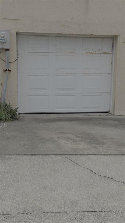 A white, multi-panel garage door is set into a beige stucco exterior wall — 500 S CENTRAL AVENUE, FLAGLER BEACH, FL