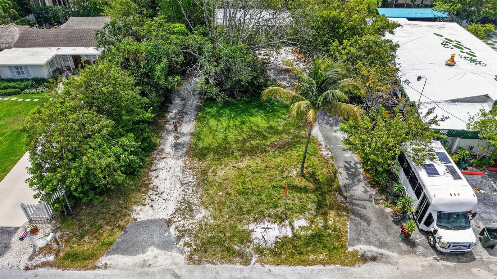 An aerial view shows a vacant, grassy lot situated between two residential properties and trees — 600 Allen Avenue, Delray Beach FL 33483, DELRAY BEACH, FL