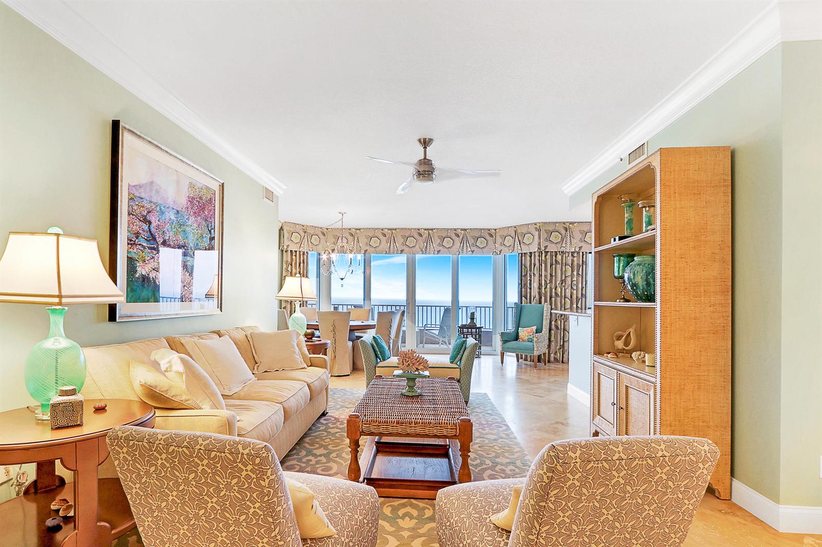 A living room with a beige sofa, patterned armchairs, a coffee table, and ocean views — 750 Ocean Royale Way # 1203, Juno Beach FL 33408, JUNO BEACH, FL