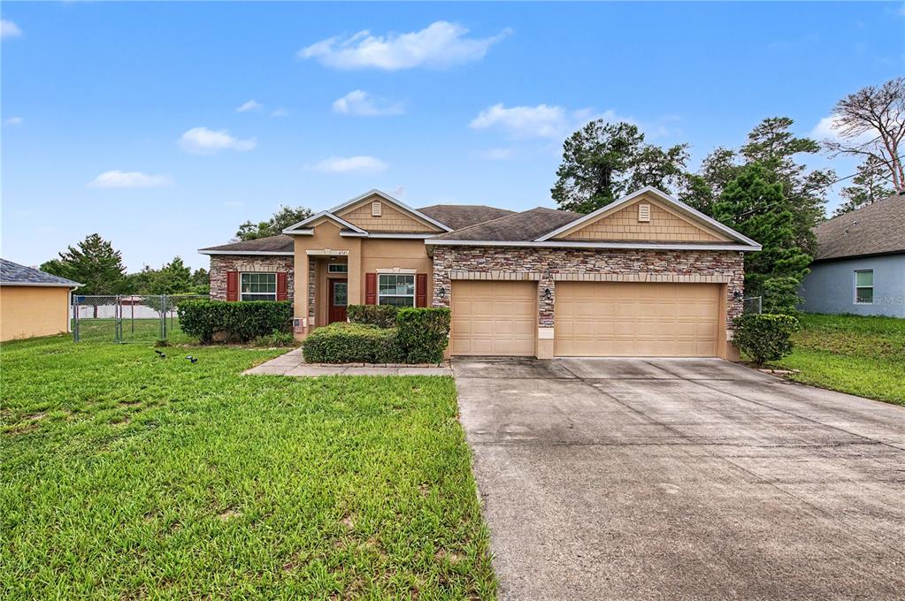 A single-story house with a stone facade, tan stucco, and a two-car garage — 6545 LANDOVER BOULEVARD, SPRING HILL, FL