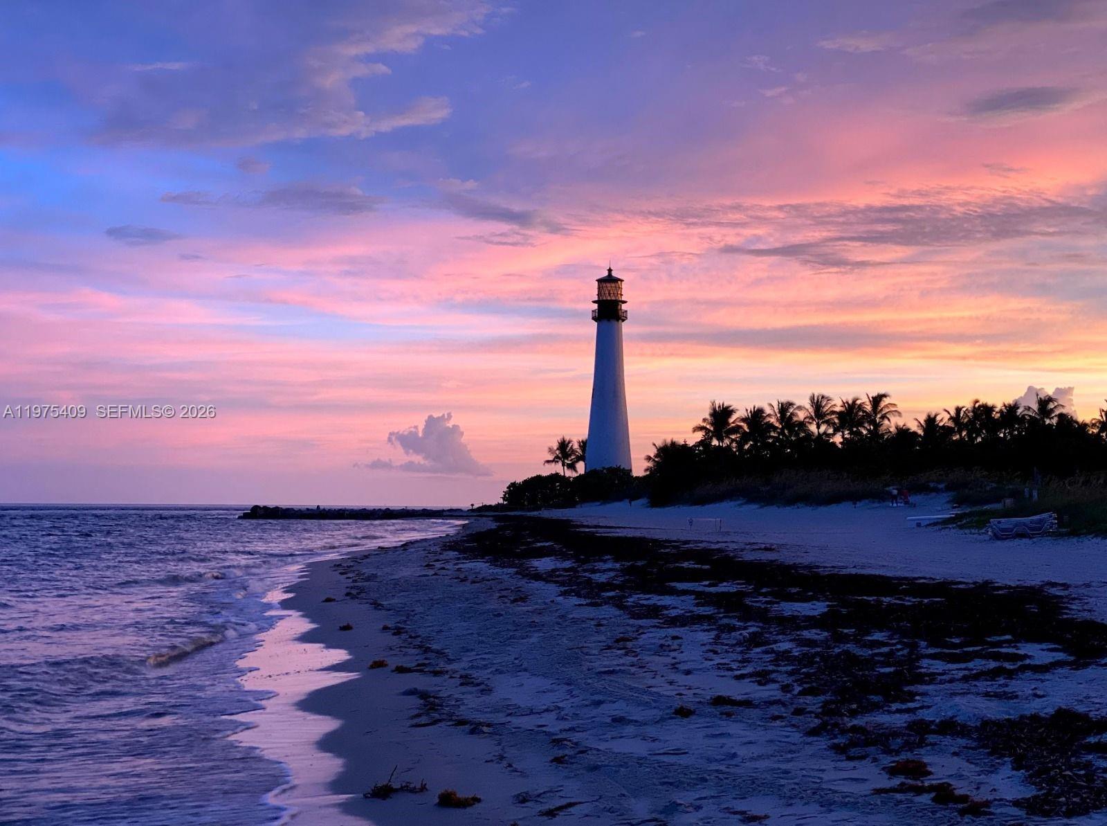 A lighthouse stands on a beach at sunset with palm trees and the ocean nearby — 881 Ocean Dr, Key Biscayne FL 33149, KEY BISCAYNE, FL