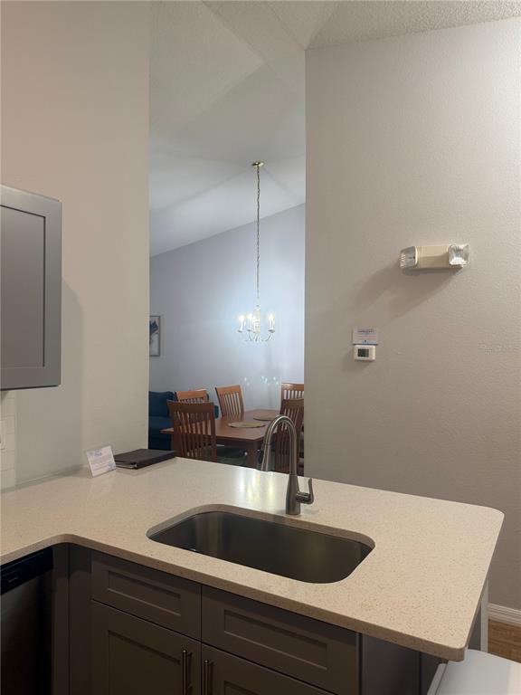 A kitchen sink and countertop overlook a dining area with a wooden table and chairs — 2774 CLUB CORTILE CIR UNIT B, KISSIMMEE, FL