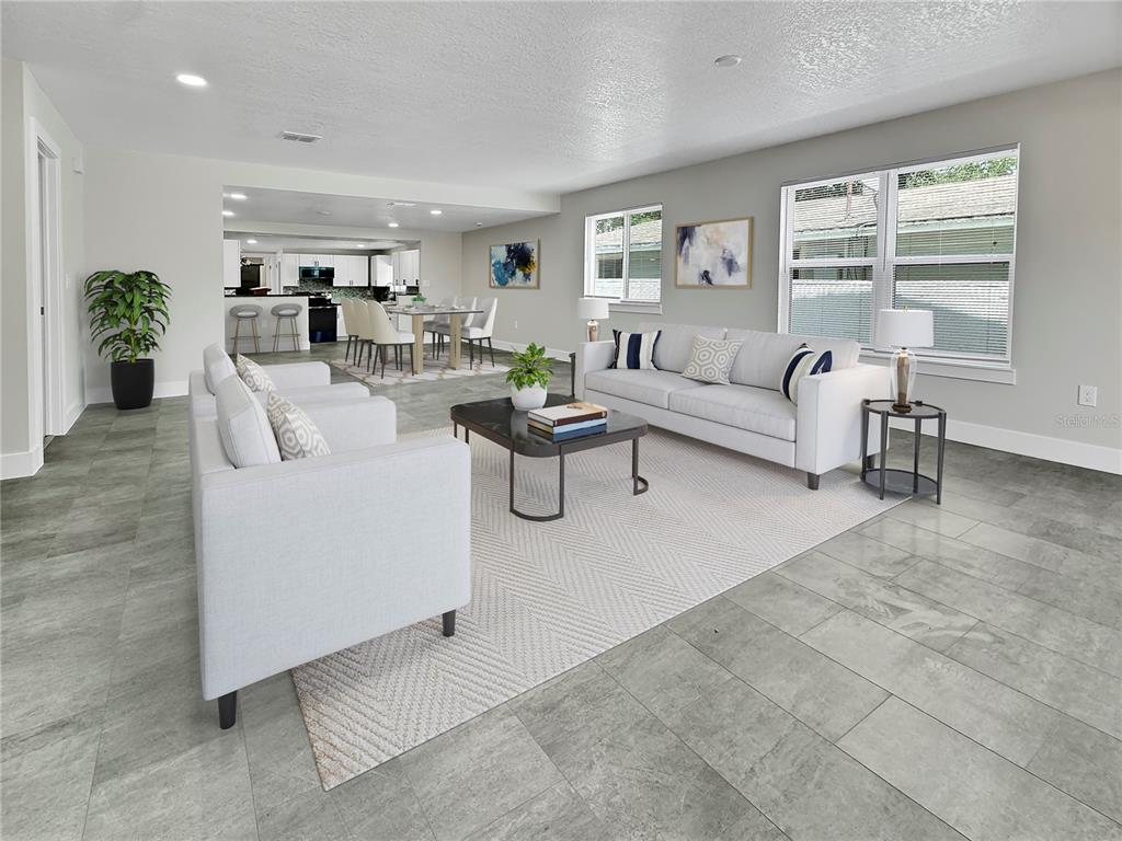 A living room with gray tile flooring, a white sofa, and an open-concept kitchen area — 0000 LENOX BOULEVARD, ORLANDO, FL