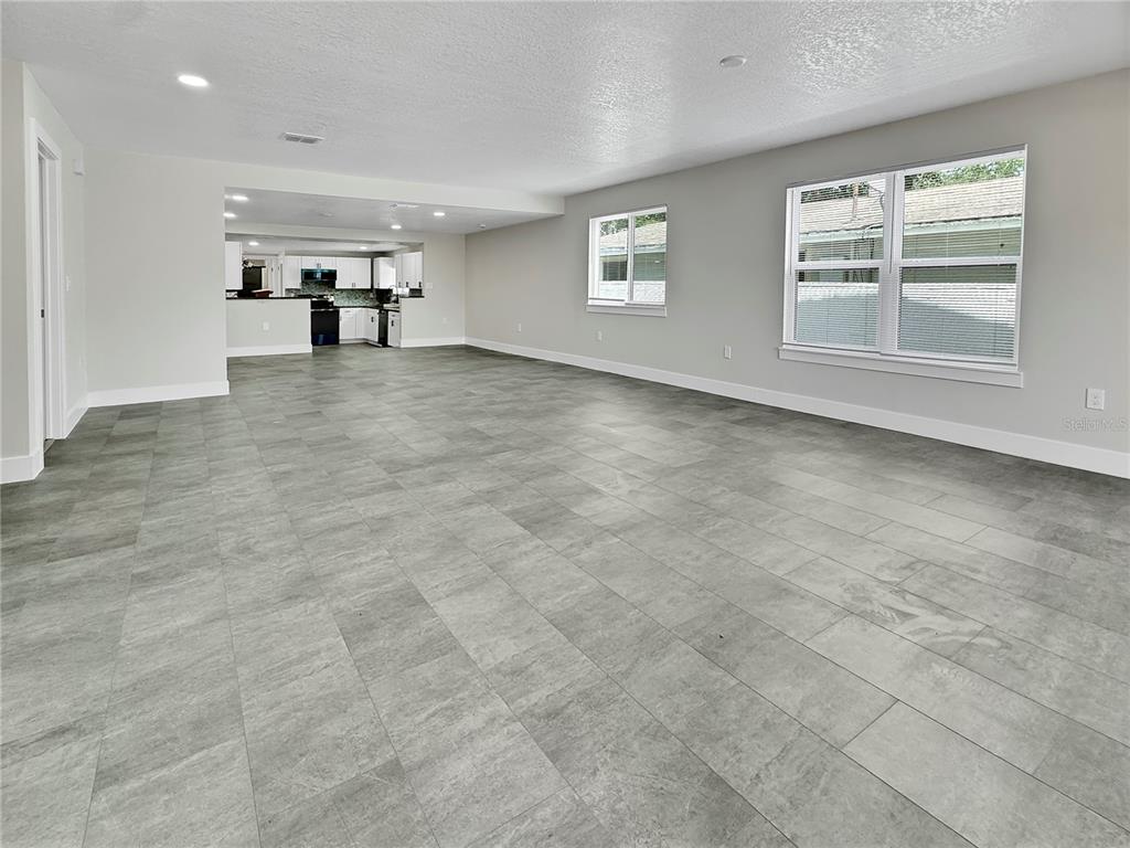A spacious, open-concept living area features gray tile flooring and white walls — 0000 LENOX BOULEVARD, ORLANDO, FL