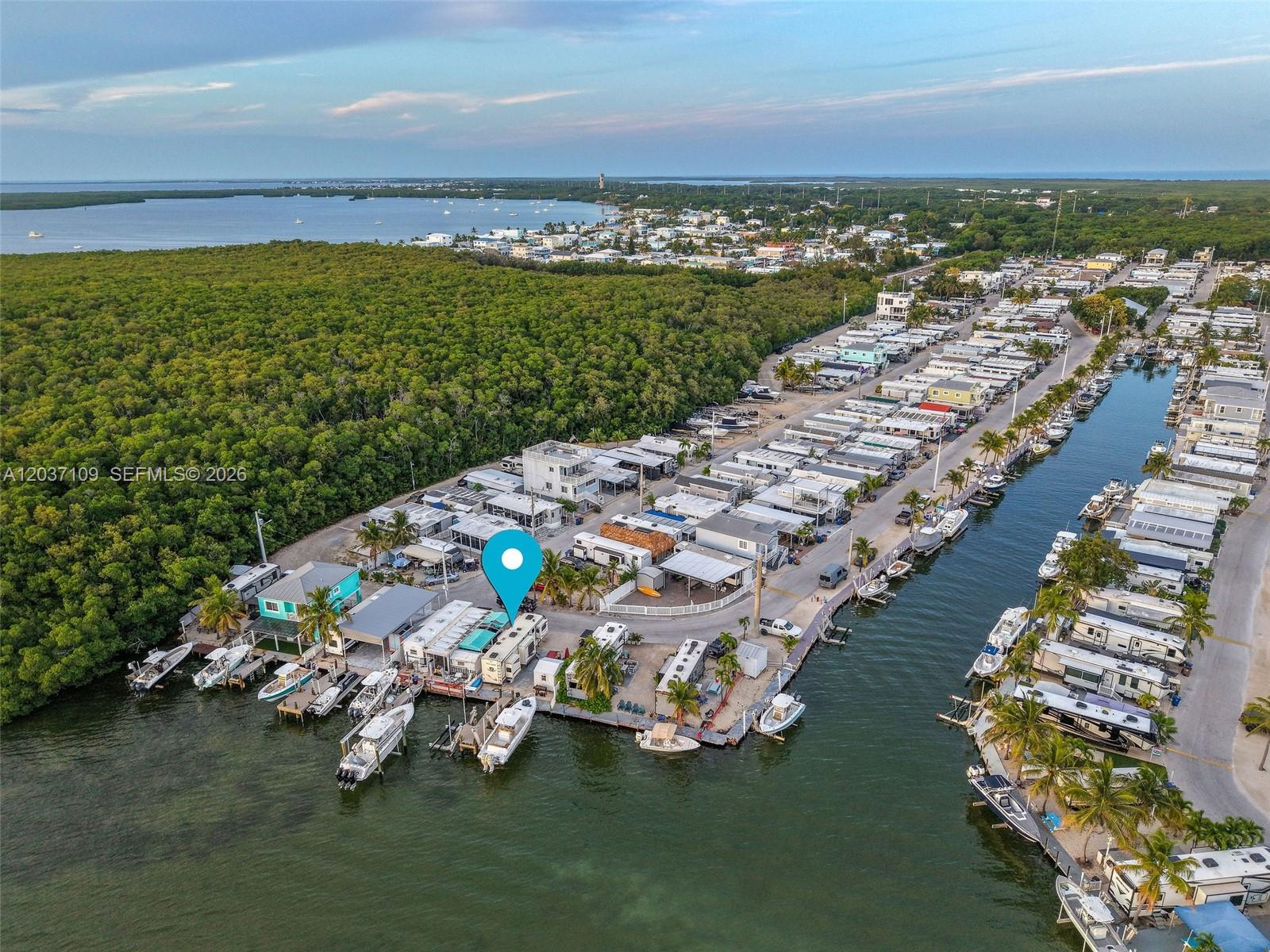 An aerial view shows a waterfront mobile home community with docks and boats in Florida — 325 Calusa St, Key Largo FL 33037, KEY LARGO, FL