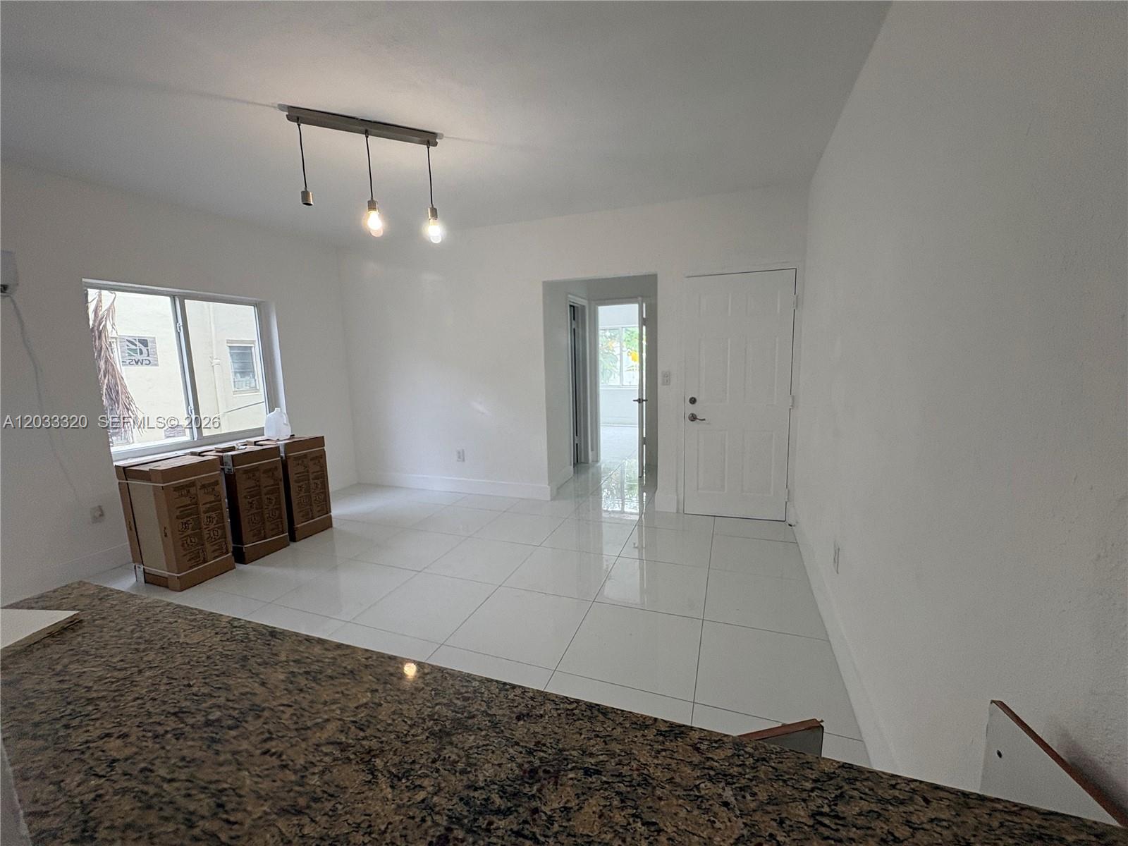 A room with white walls, large white floor tiles, and a granite-topped counter — 7920 Harding Ave # 8, Miami Beach FL 33141, MIAMI BEACH, FL