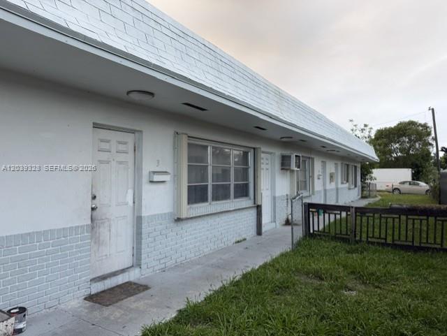 A single-story apartment building with white walls, brick accents, and a row of entry doors — 2128 Roosevelt St # 3, Hollywood FL 33020, HOLLYWOOD, FL